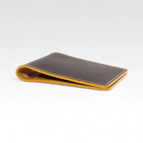 Elvis & Kresse credit card holder made from black reclaimed printing blanket and yellow decommissioned fire-hose