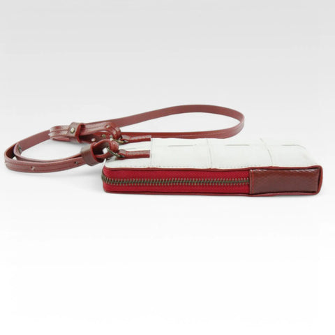 The Elvis & Kresse Crossbody Pouch, available in white upcycled leather and red recycled fire-hose