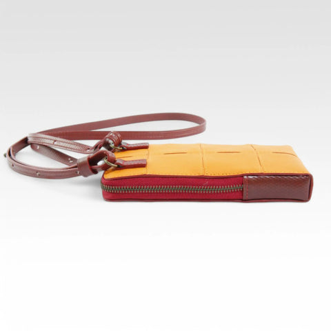 The Elvis & Kresse Crossbody Pouch, available in orange upcycled leather and red recycled fire-hose