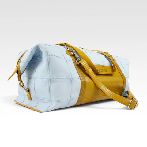 The Elvis & Kresse Weekend Bag, available in pale blue upcycled leather and yellow recycled fire-hose