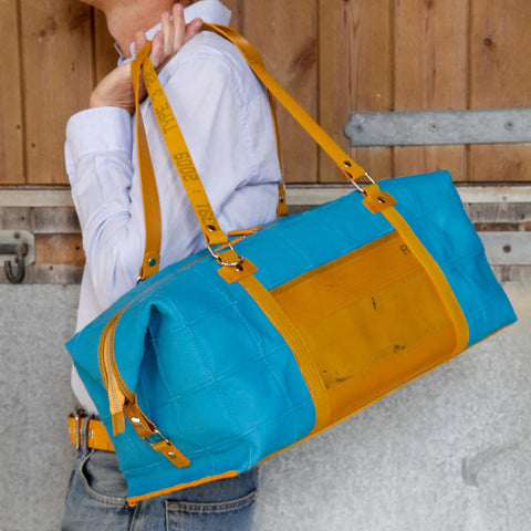 The Elvis & Kresse Weekend Bag, available in Mediterranean blue upcycled leather and yellow recycled fire-hose