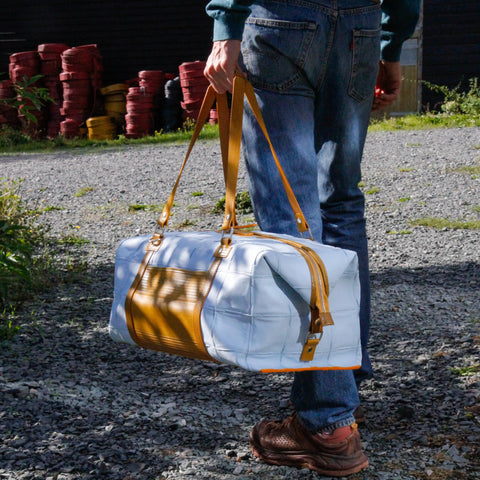 The Elvis & Kresse Weekend Bag, available in pale blue upcycled leather and yellow recycled fire-hose